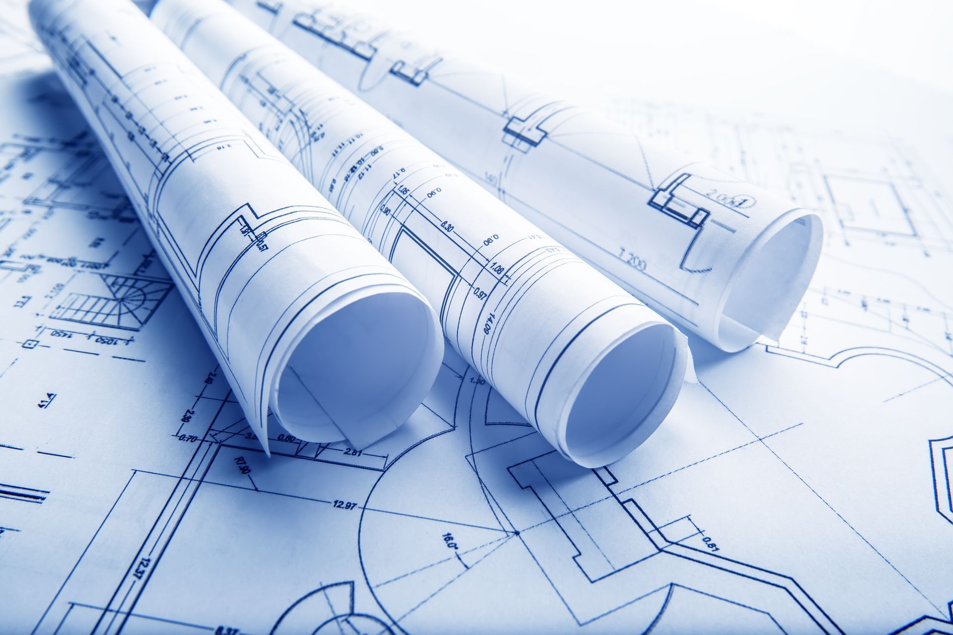 Three rolls of blueprints are stacked on top of each other