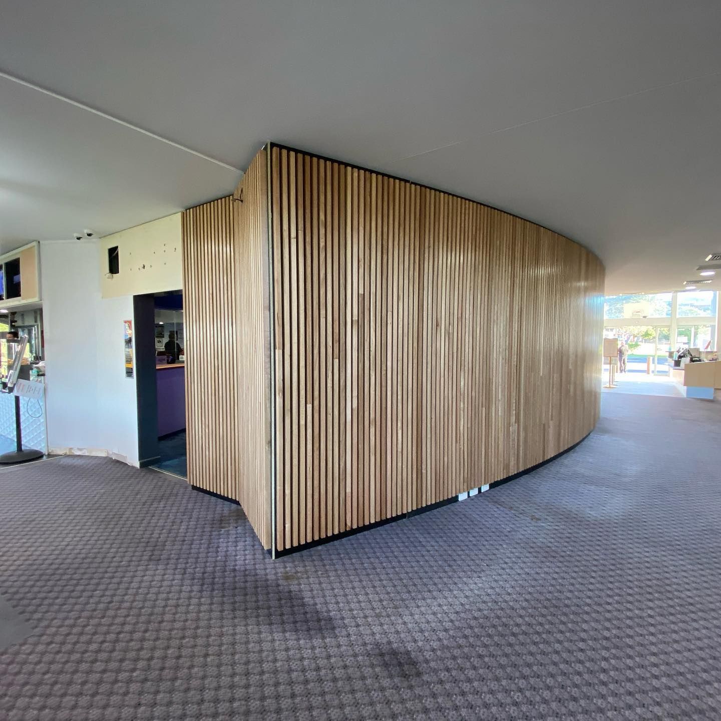 A Wooden Slatted Wall in A Curved Hallway — Coastline Building & Renovations In Forster, NSW