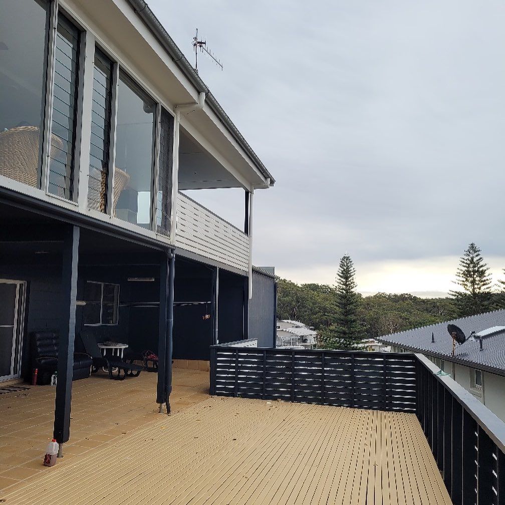 A House with A Wooden Deck and Black Railings — Coastline Building & Renovations In Forster, NSW