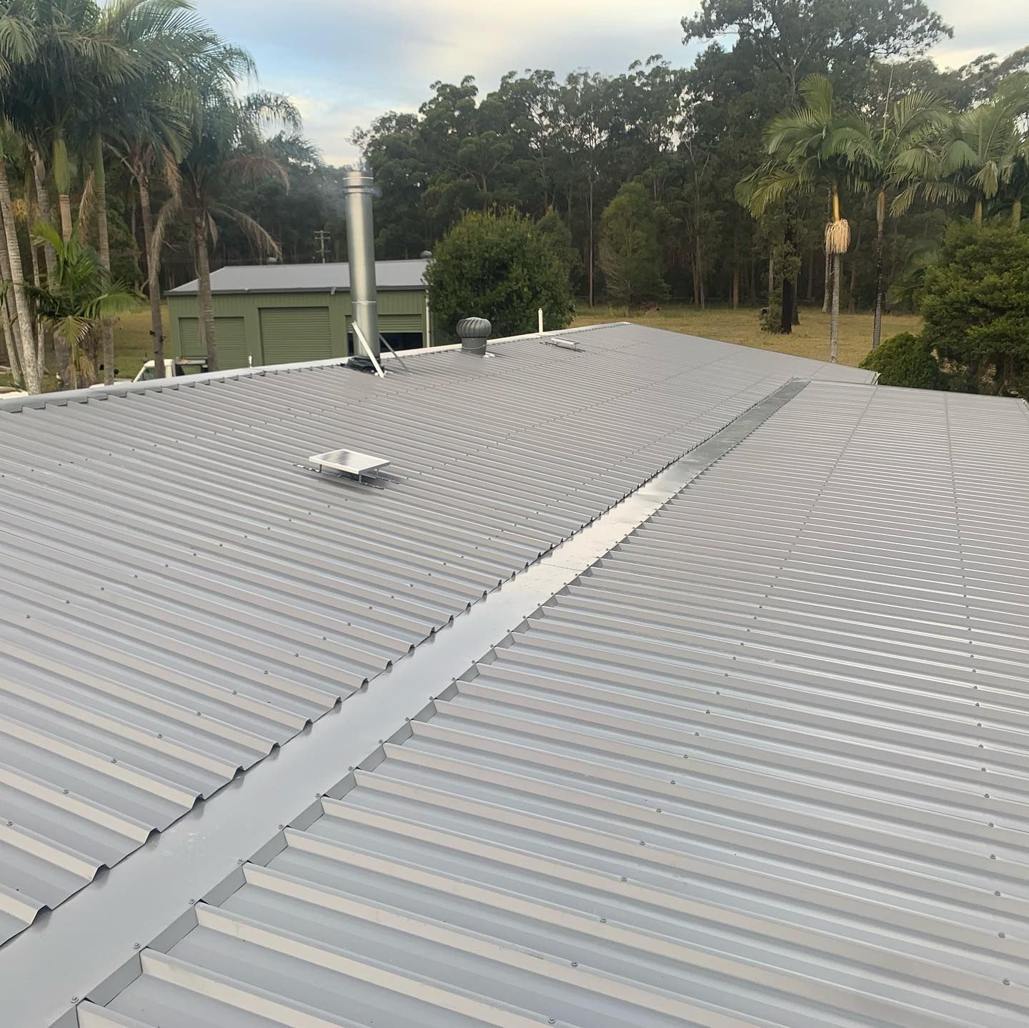 A Gray Metal Roof with Drainage Channel — Coastline Building & Renovations In Smiths Lake, NSW