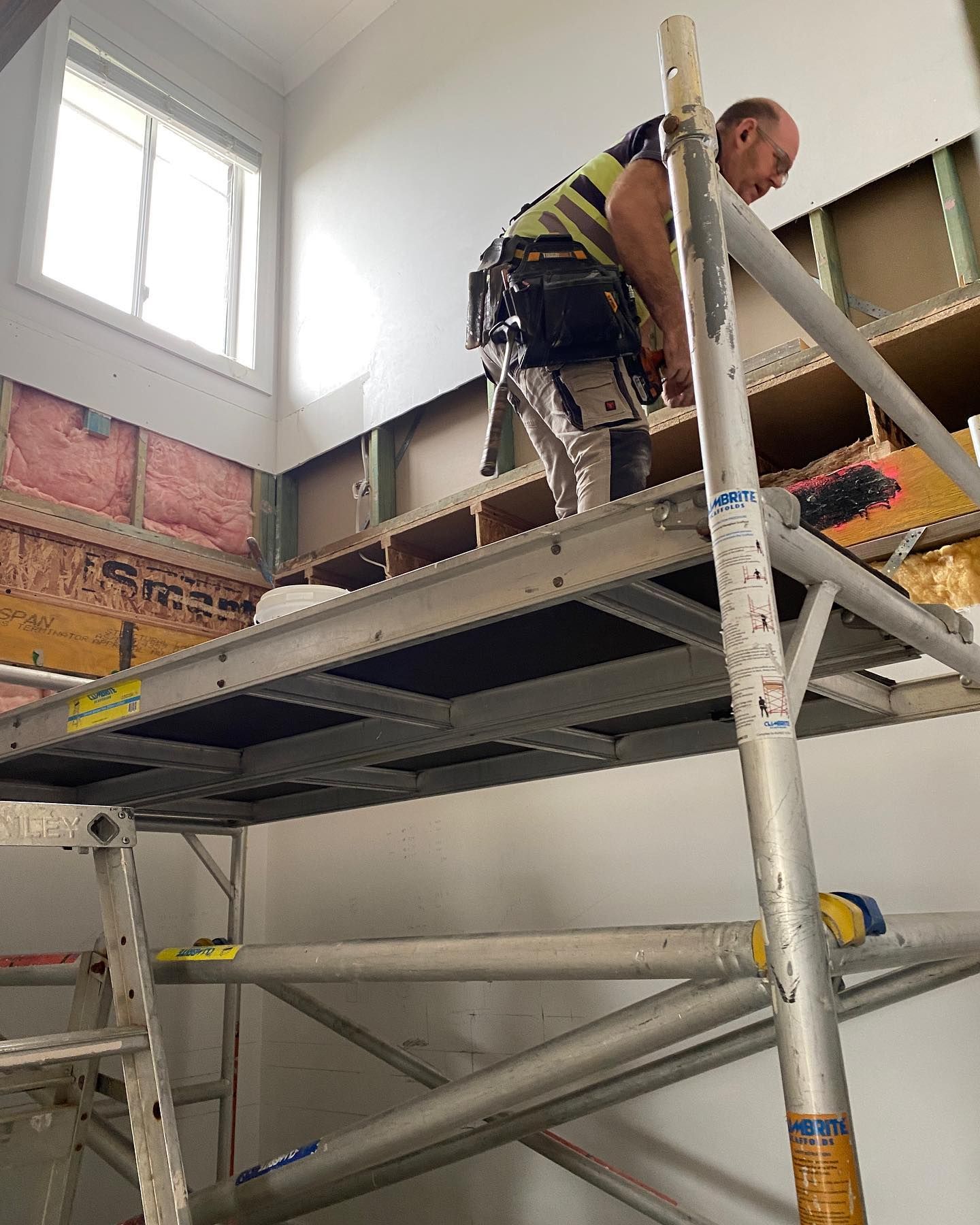 A Construction Worker Installing Drywall — Coastline Building & Renovations In Forster, NSW