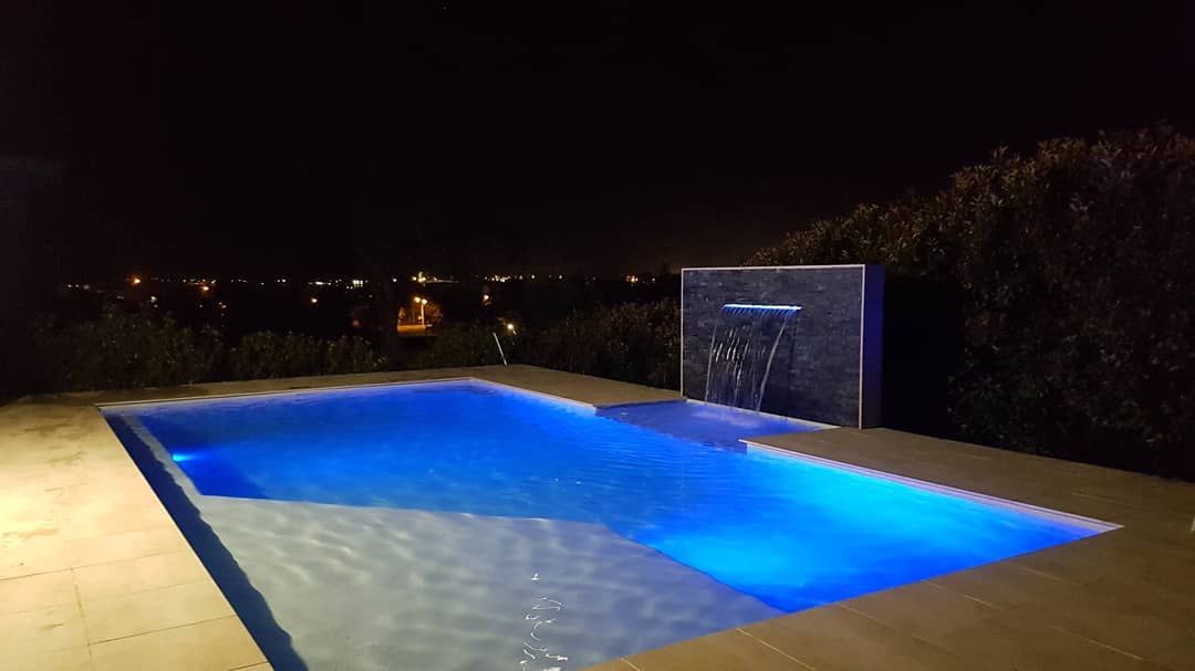 A Swimming Pool with A Waterfall — Coastline Building & Renovations In Forster, NSW