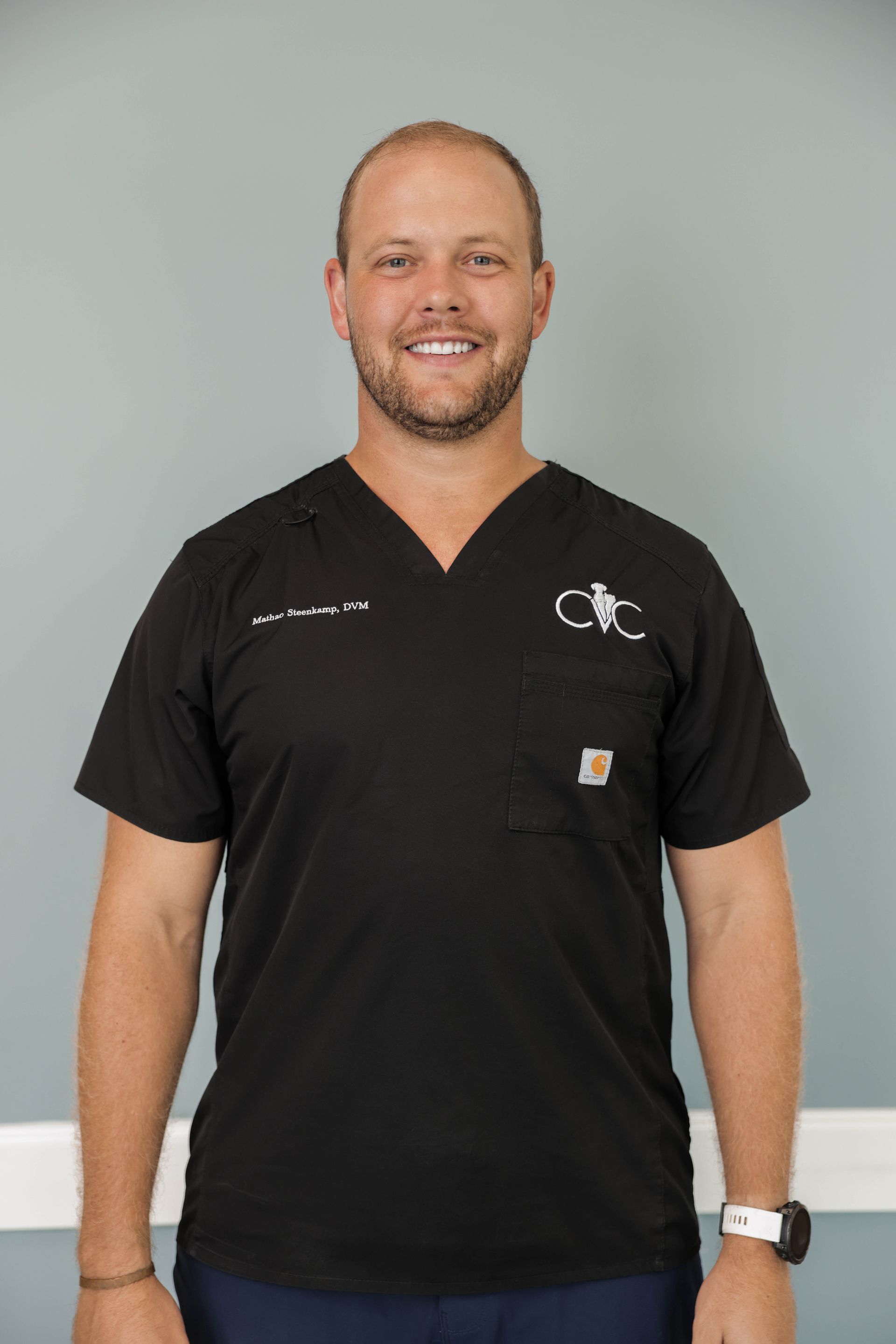 a man wearing a black scrub top with the word cvc on it