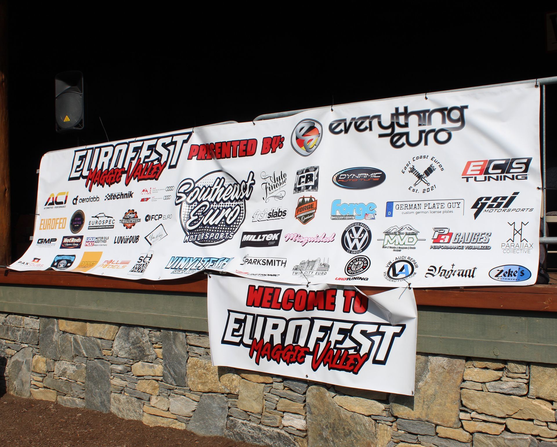 Event sponsor banner for Eurofest displayed on a stone wall at night.