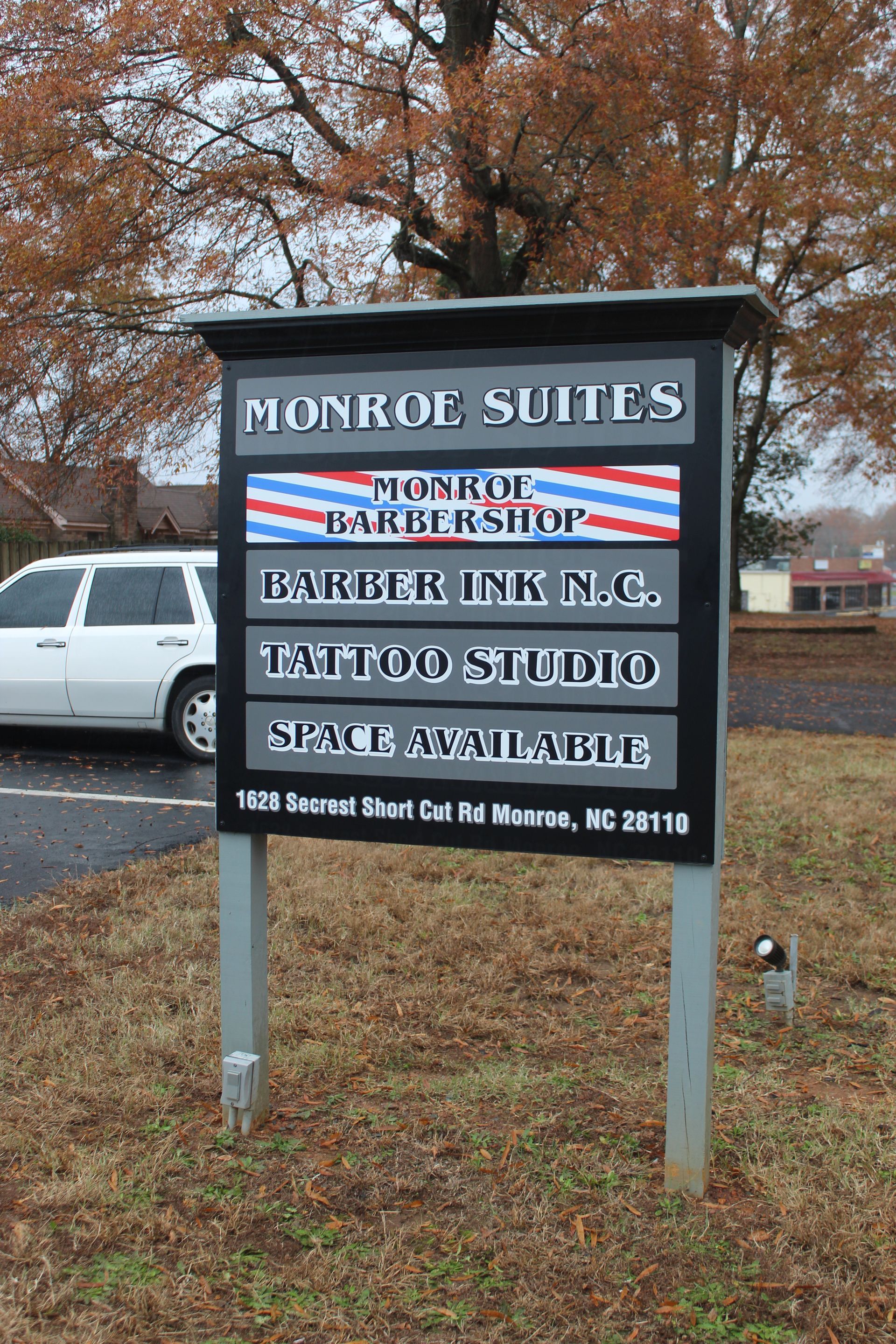 Business sign for Monkey Suites and Monkey Business Inc., in a wooded outdoor setting