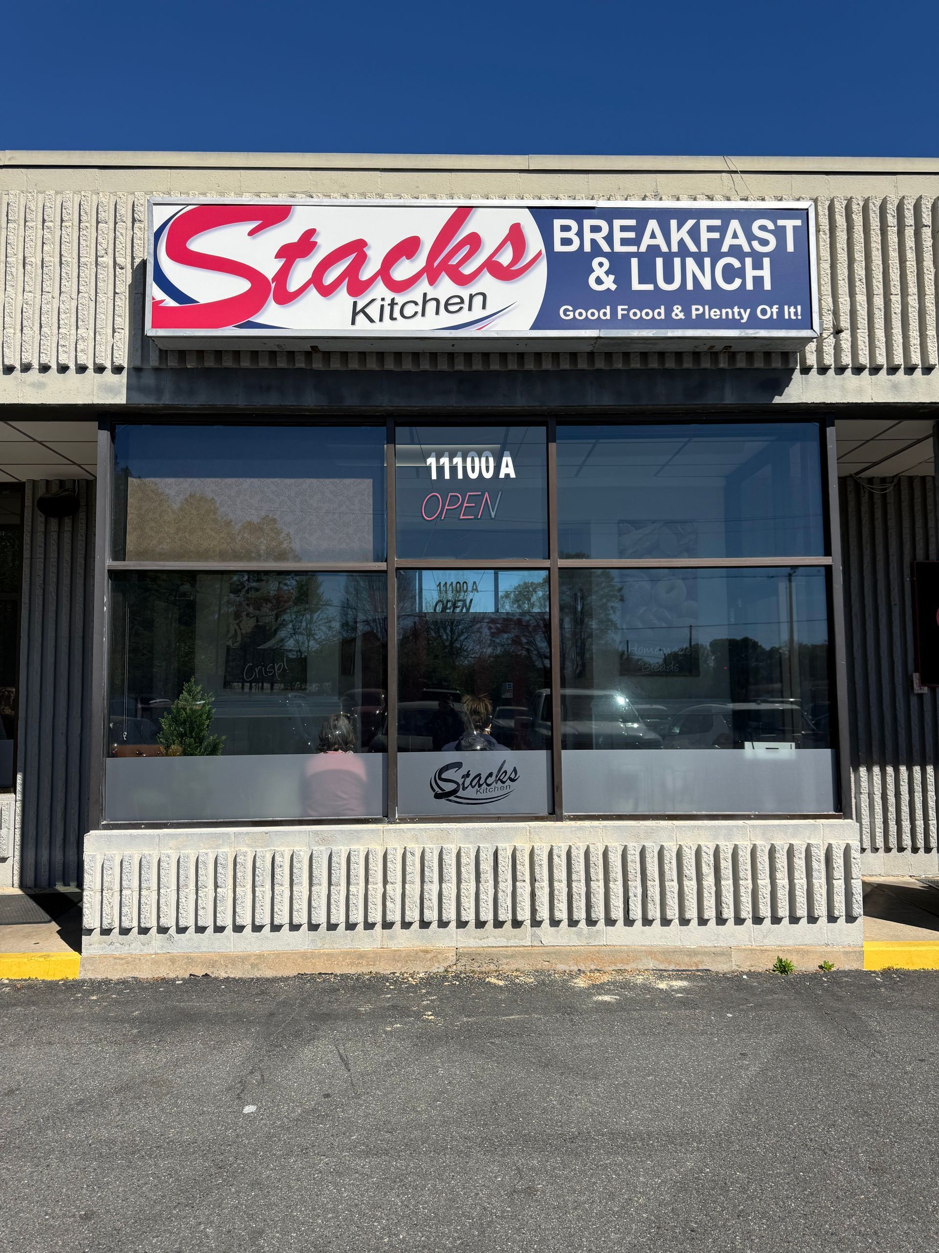 Storefront for Stacks breakfast and lunch with large windows and a blue awning.