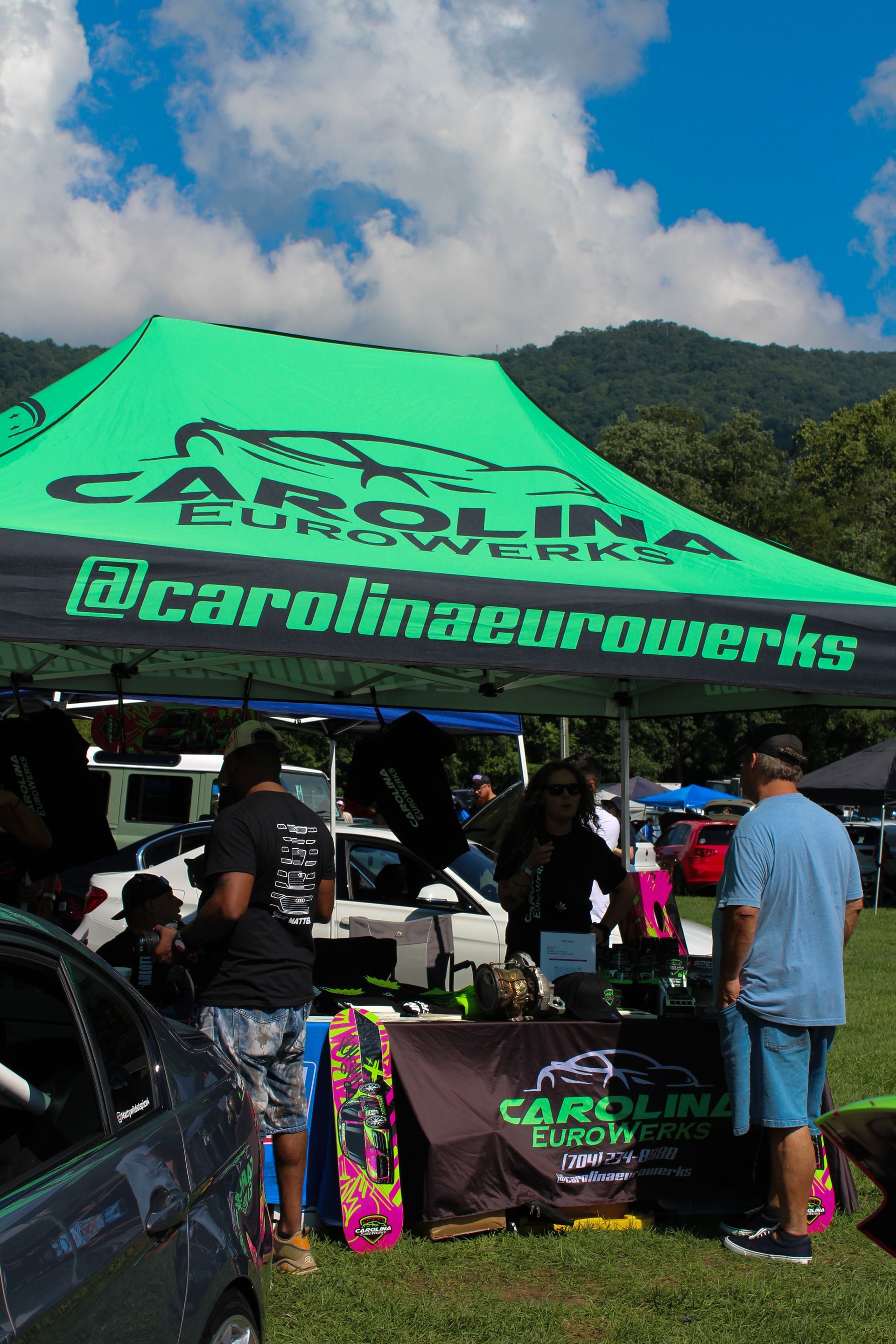 Bright green tent with Carolina Turboweeks branding at an outdoor event, with people gathered underneath.