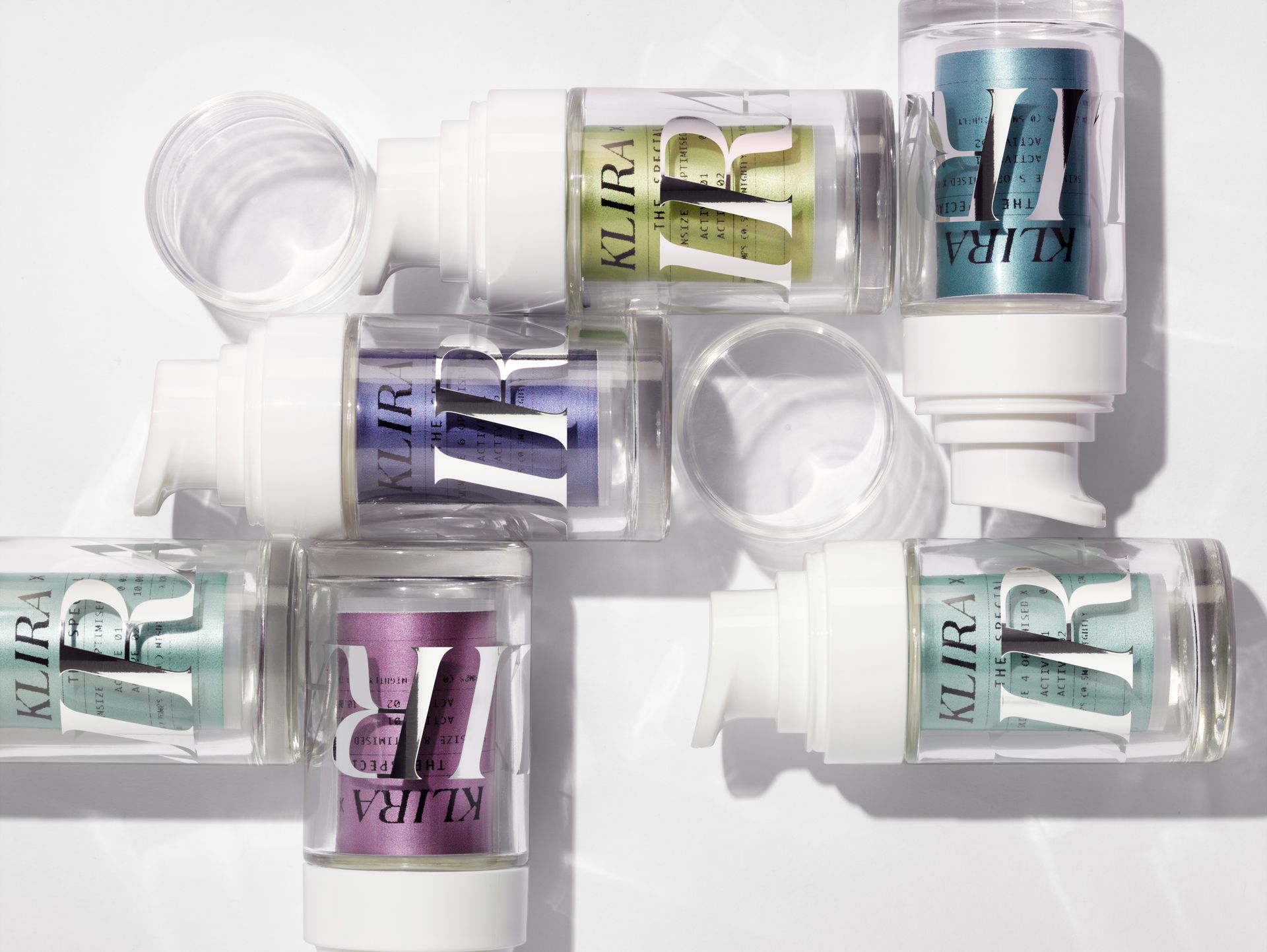 Various colorful makeup containers with white pumps, labeled 