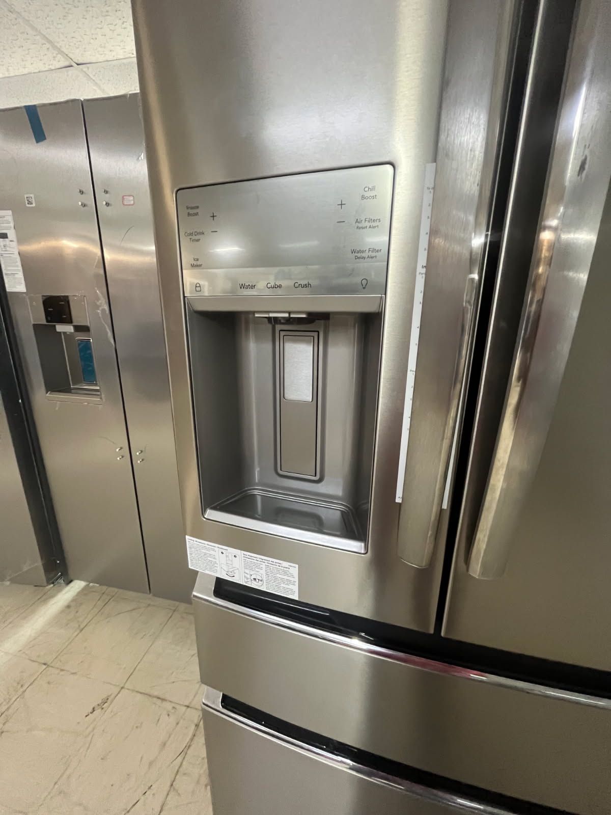 Stainless steel refrigerator with built-in water and ice dispenser in a kitchen