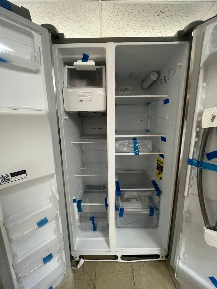 Open, empty refrigerator with blue tape and shelves visible inside