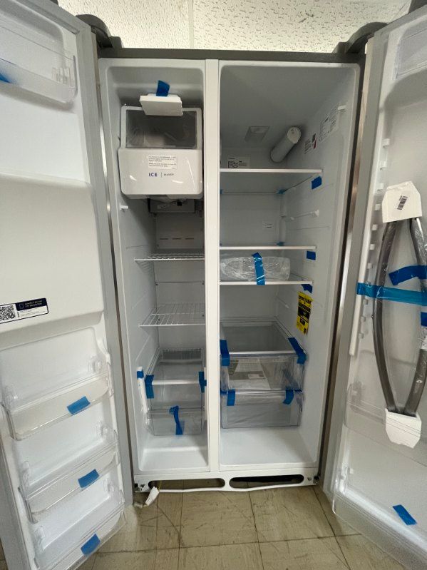Open refrigerator with mostly empty shelves and blue tape marking compartments