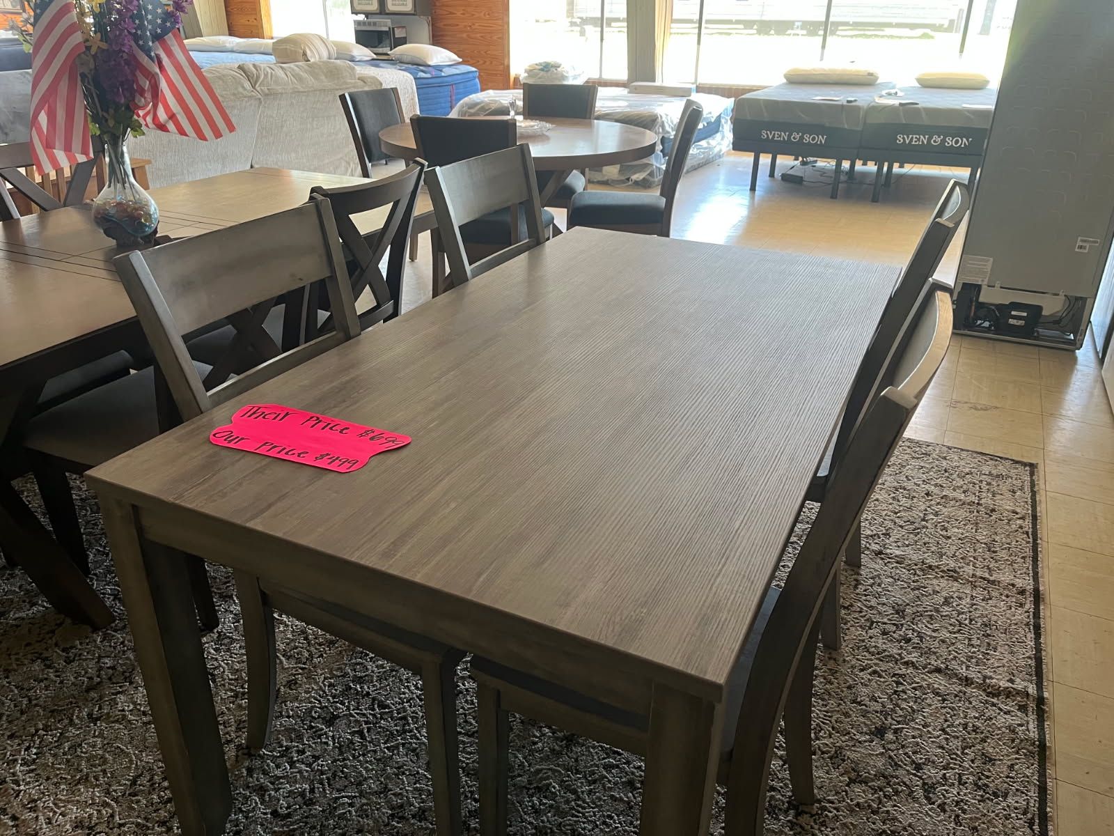 Dining table and chairs in a bright room, with a pink note on the table.