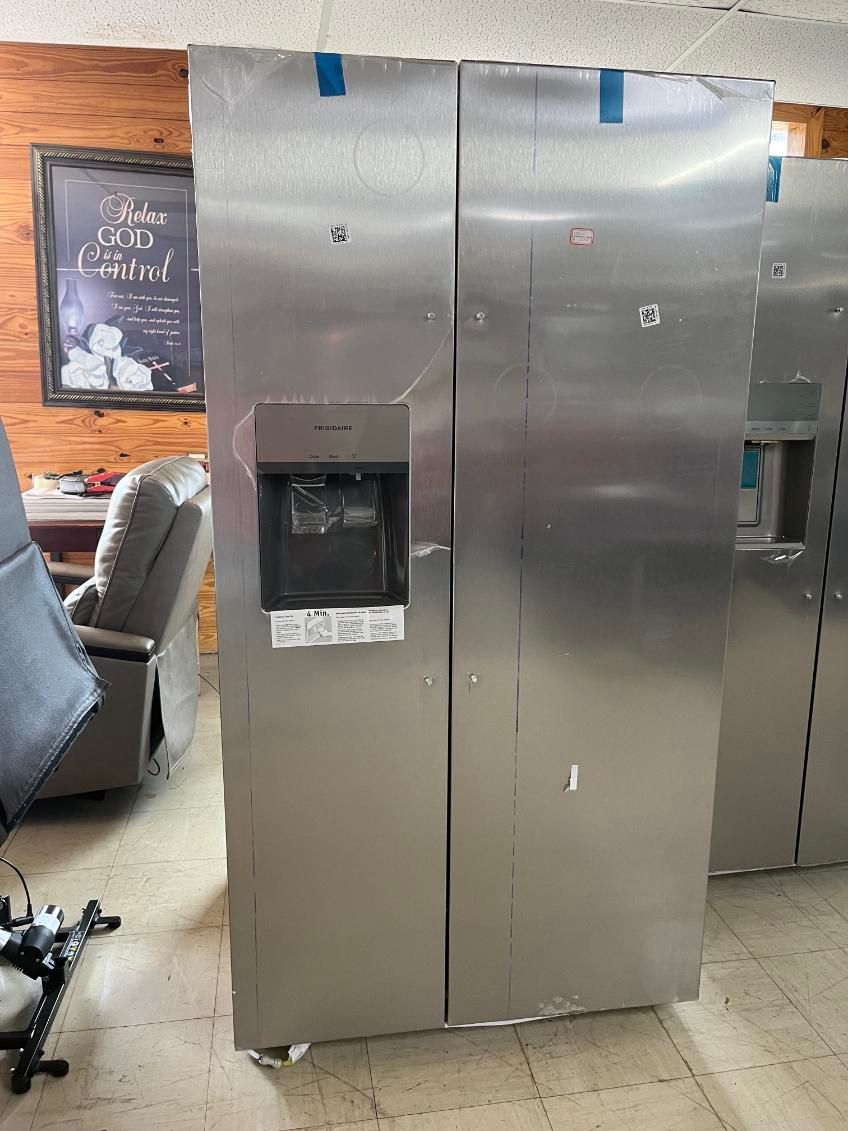 Stainless steel side-by-side refrigerator in a showroom, with water and ice dispensers visible.