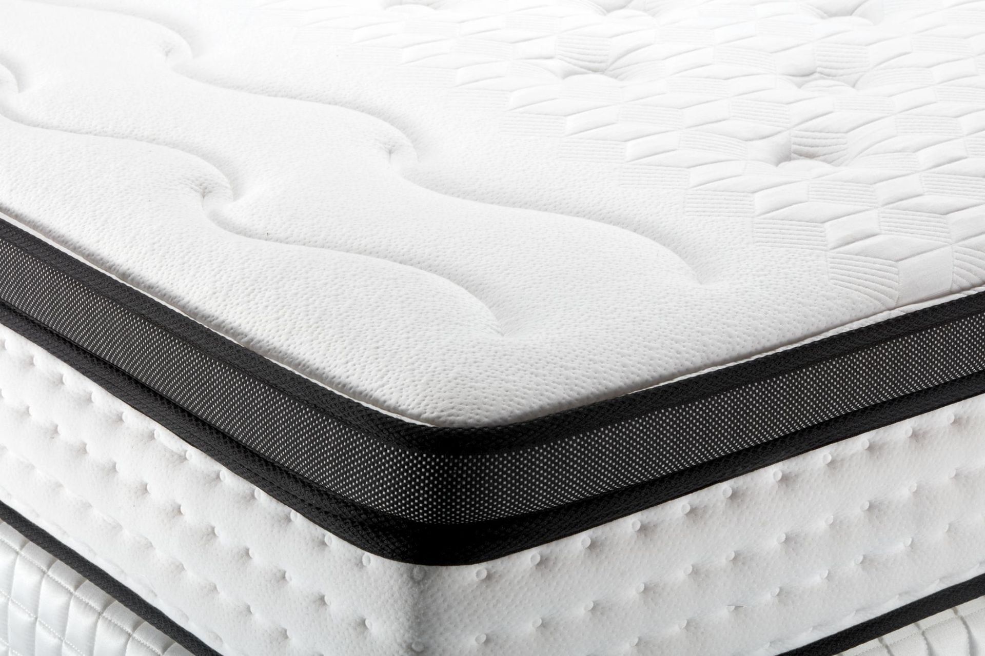 Close-up of a white mattress with a black quilted edge trim.