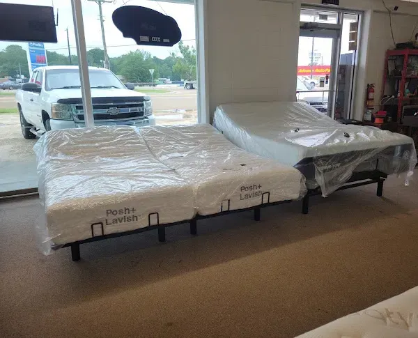 Mattresses wrapped in plastic displayed in a furniture store showroom near large windows