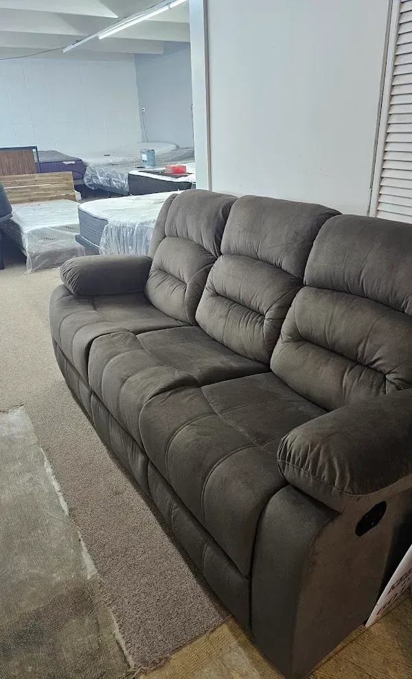 Brown recliner sofa in a showroom with other furniture in the background