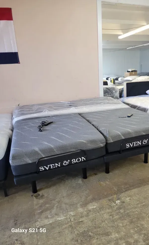 Two black RV mattresses with gray covers in a room, one with keys on top