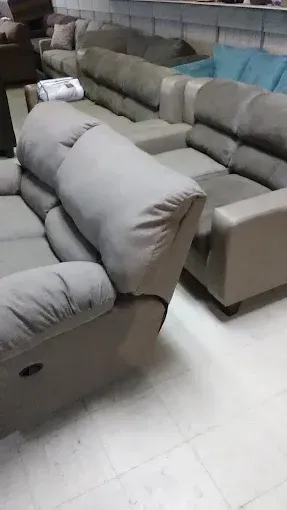 Gray sectional sofas arranged in a showroom on a white tile floor