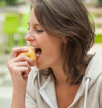 Woman eating an apple with implants