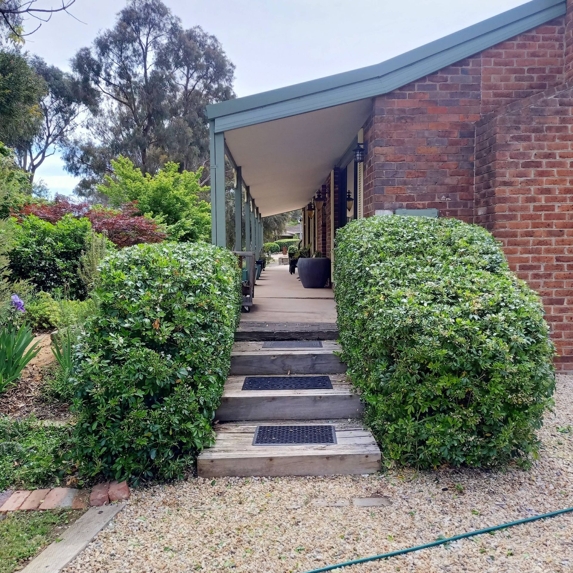 Steps Leading To A Covered Walkway Of A Brick Building — Your Garden in Gungahlin, ACT