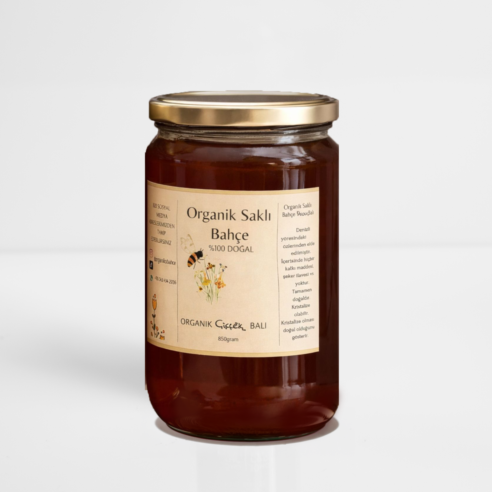 Glass jar of organic sauce with a gold lid and beige label on a white background