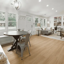 Bright open living-dining room with large windows, light wood floors, and modern white furniture