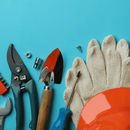 Assorted hand tools and gloves arranged along the bottom on a bright blue background