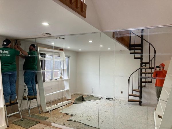 Man Fixing Mirror - Glenolden, PA - McGrory Moving A junk removal specialist providing services in Springfield, PA