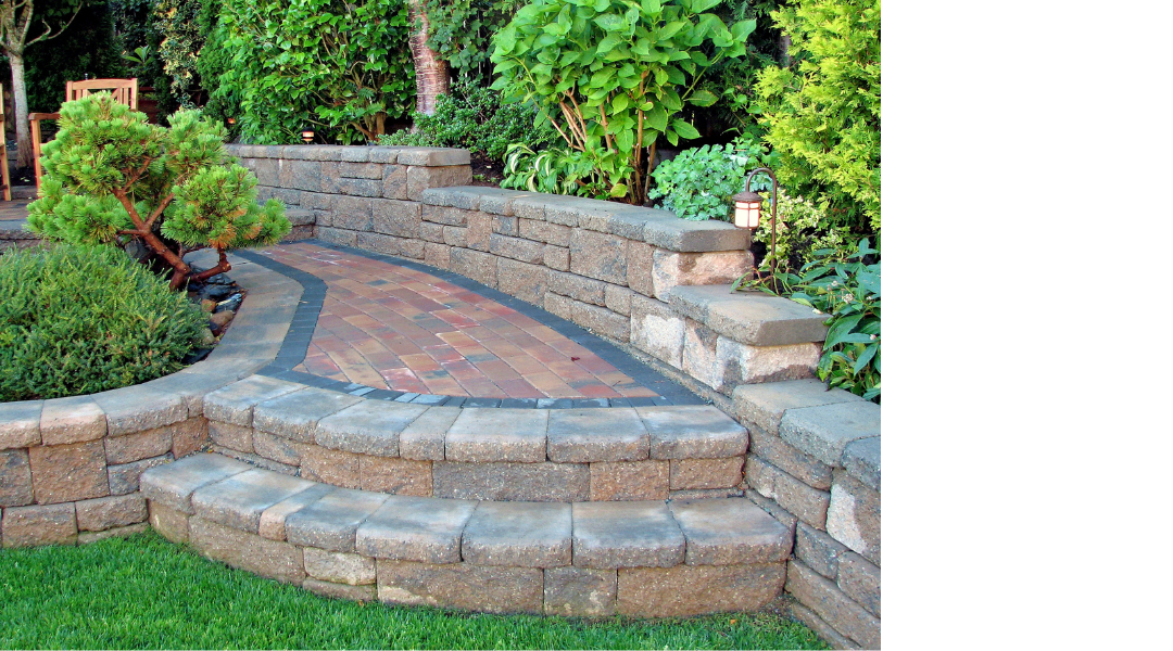 Curved stone garden steps with a brick path, bordered by retaining walls and lush greenery.