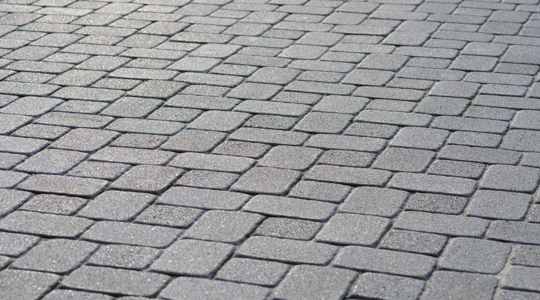 Gray cobblestone pavement laid in a repeating brick pattern