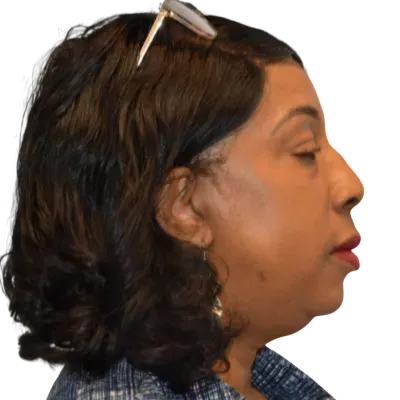 Side profile of a woman with dark hair and glasses on her head, wearing red lipstick against a white background