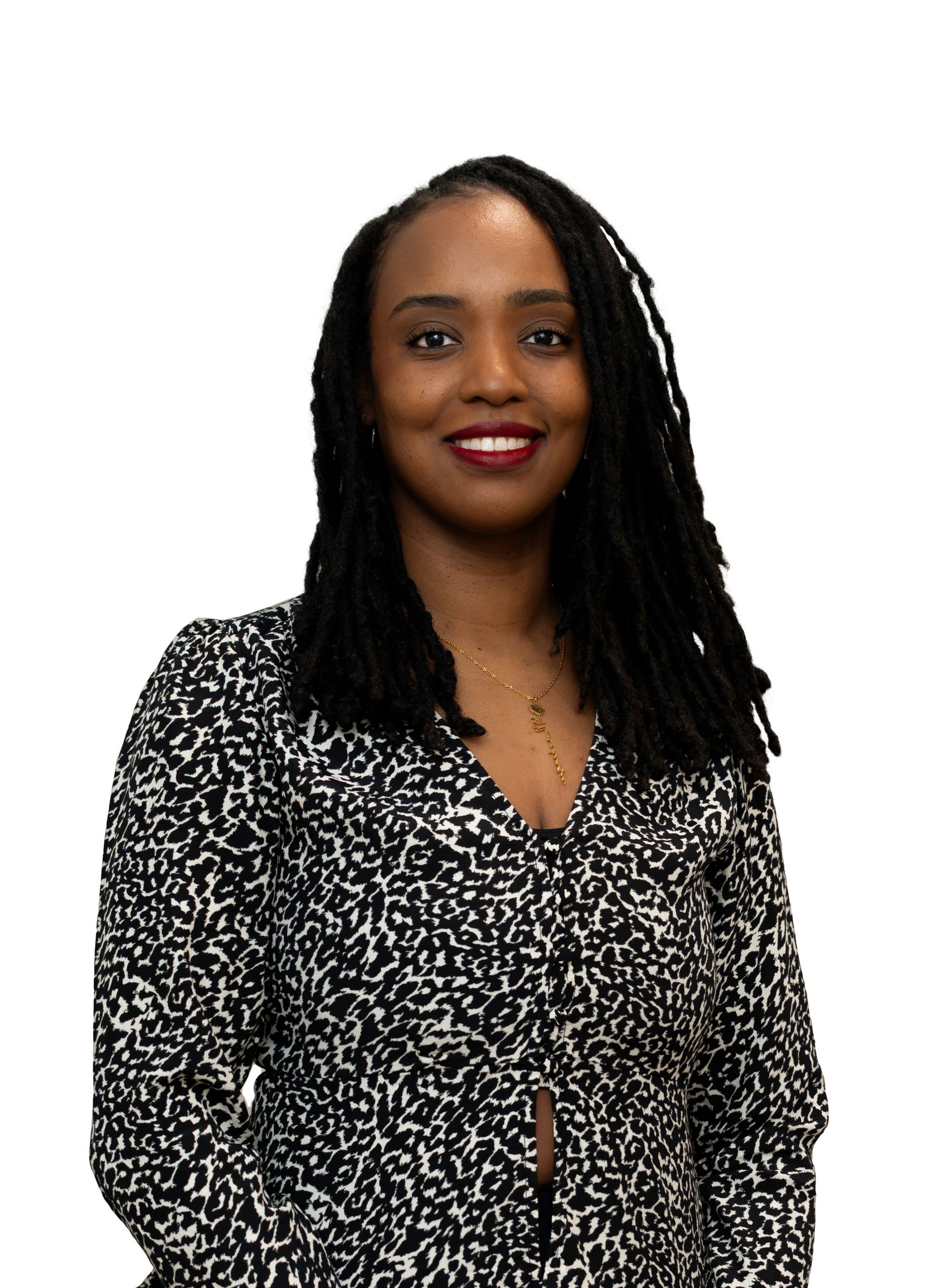 Portrait of a smiling person with long dark hair, wearing a black-and-white patterned blouse against a white background