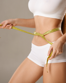 Person measuring waist and hips with a yellow tape measure, wearing white underwear and sports bra