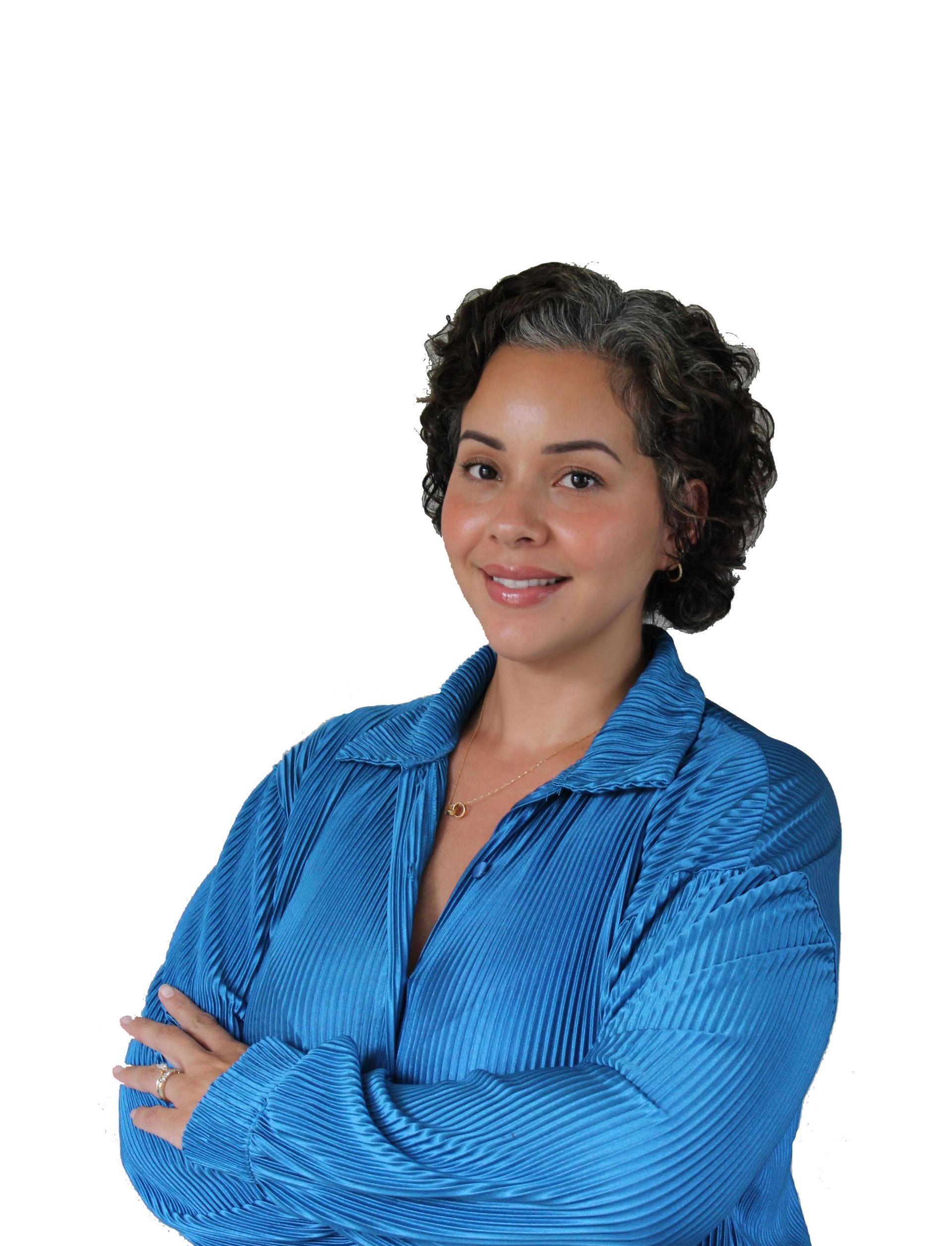 Smiling person in a blue shirt with arms crossed against a white background