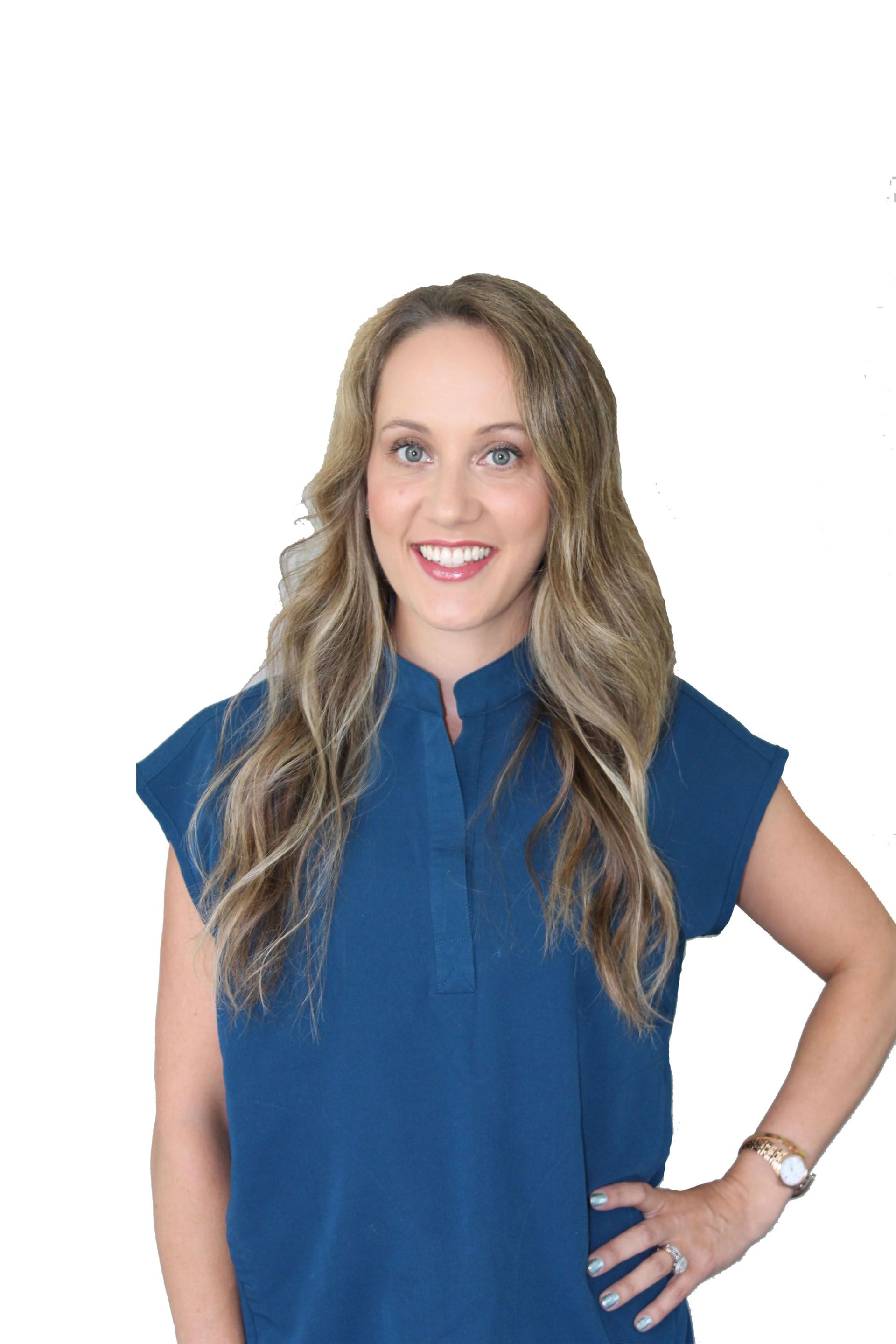 Smiling woman in a blue blouse, standing with one hand on her hip against a white background