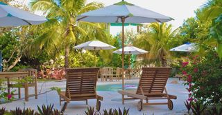 A swimming pool with chairs and umbrellas in the background