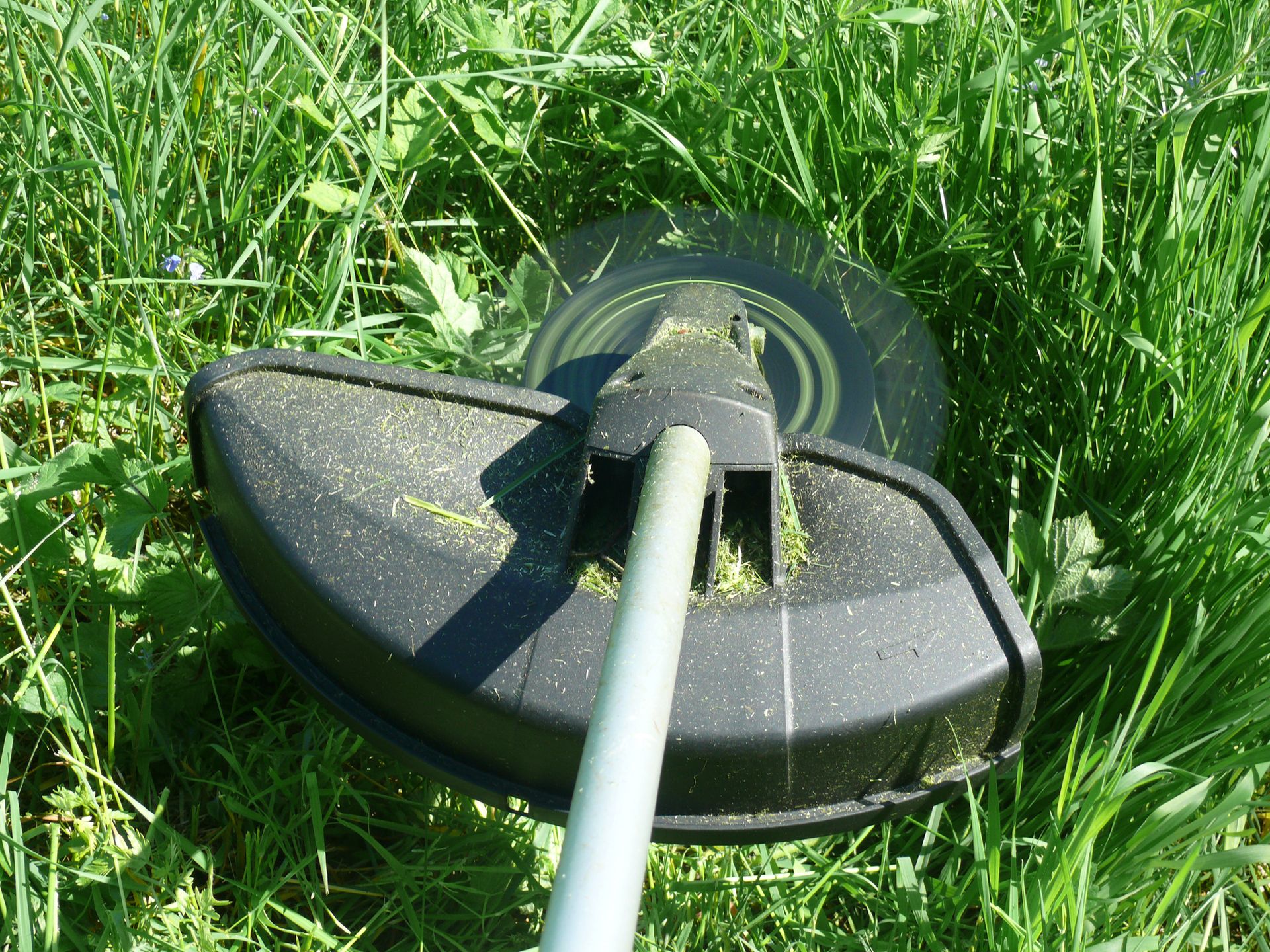 A close up of a lawn mower in the grass