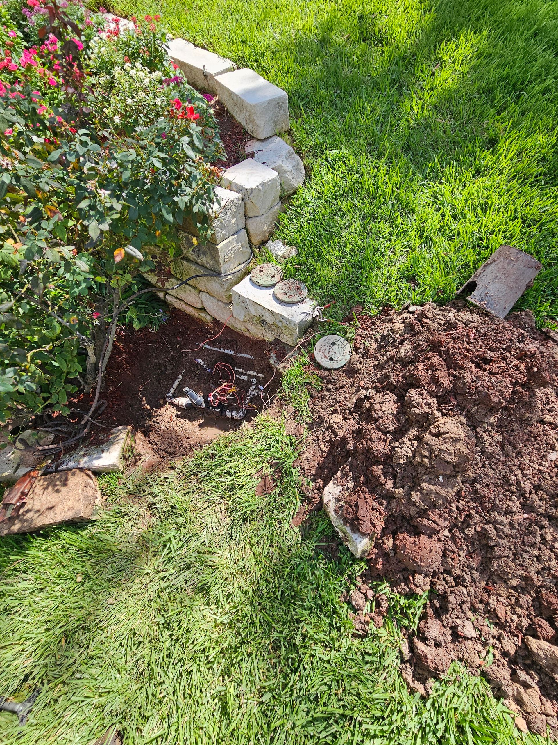 A shovel is sitting on top of a pile of dirt in a garden.