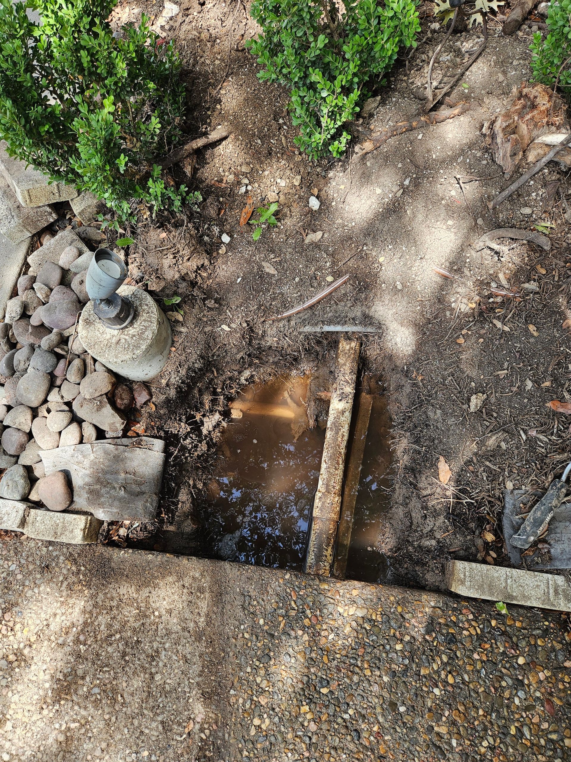 There is a hole in the ground with water coming out of it.