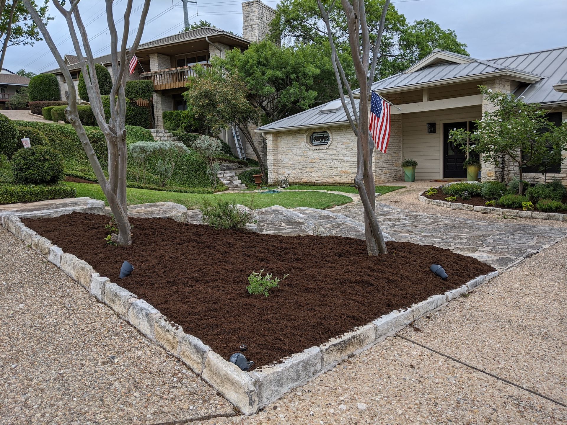 A house with a flag in front of it and a garden in front of it.