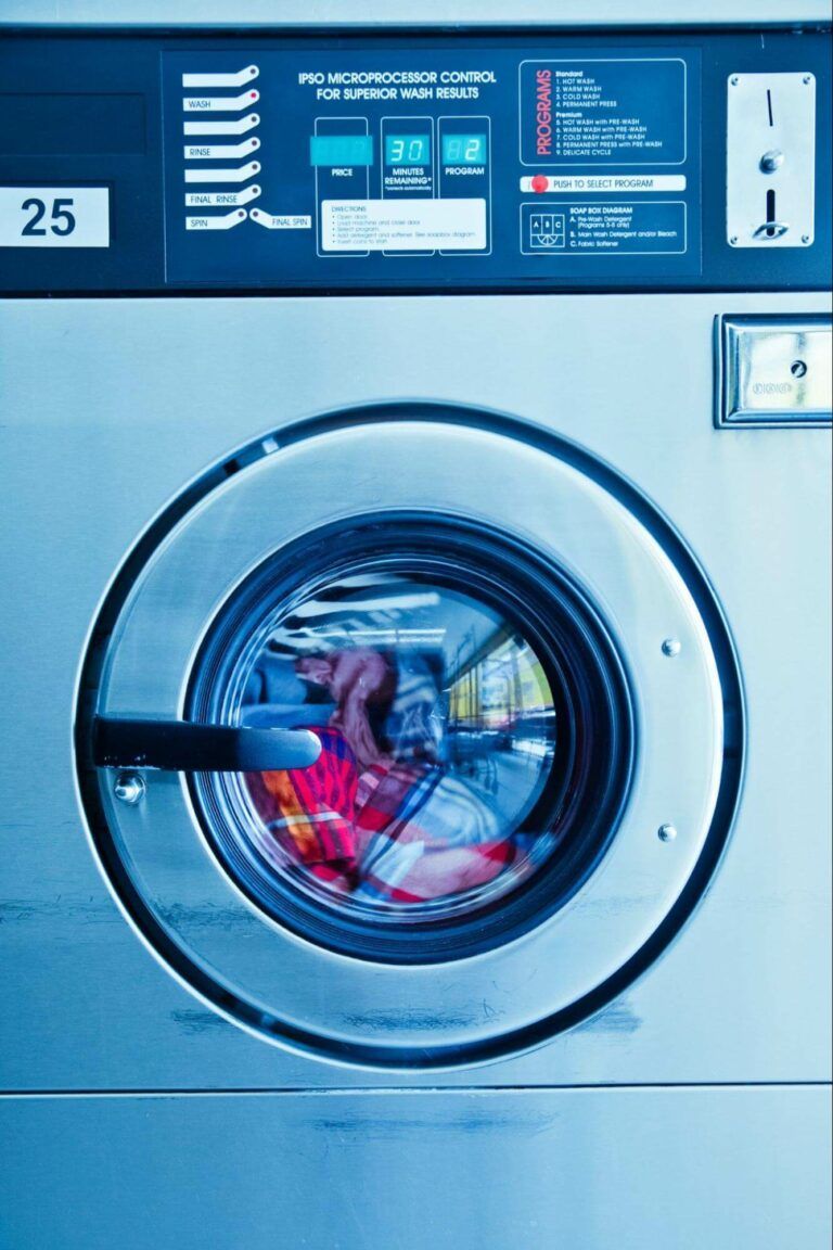 A blue-tinted front-loading commercial laundry machine marked with the number 25.