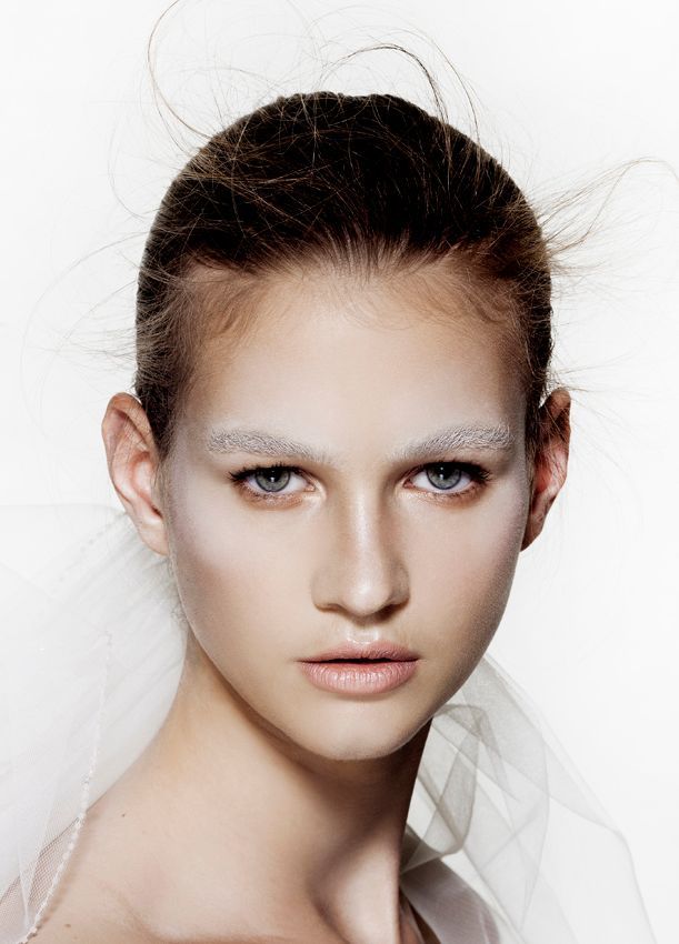 Vrouw met een lichte huid, matte witte wenkbrauwen en lichte make-up.