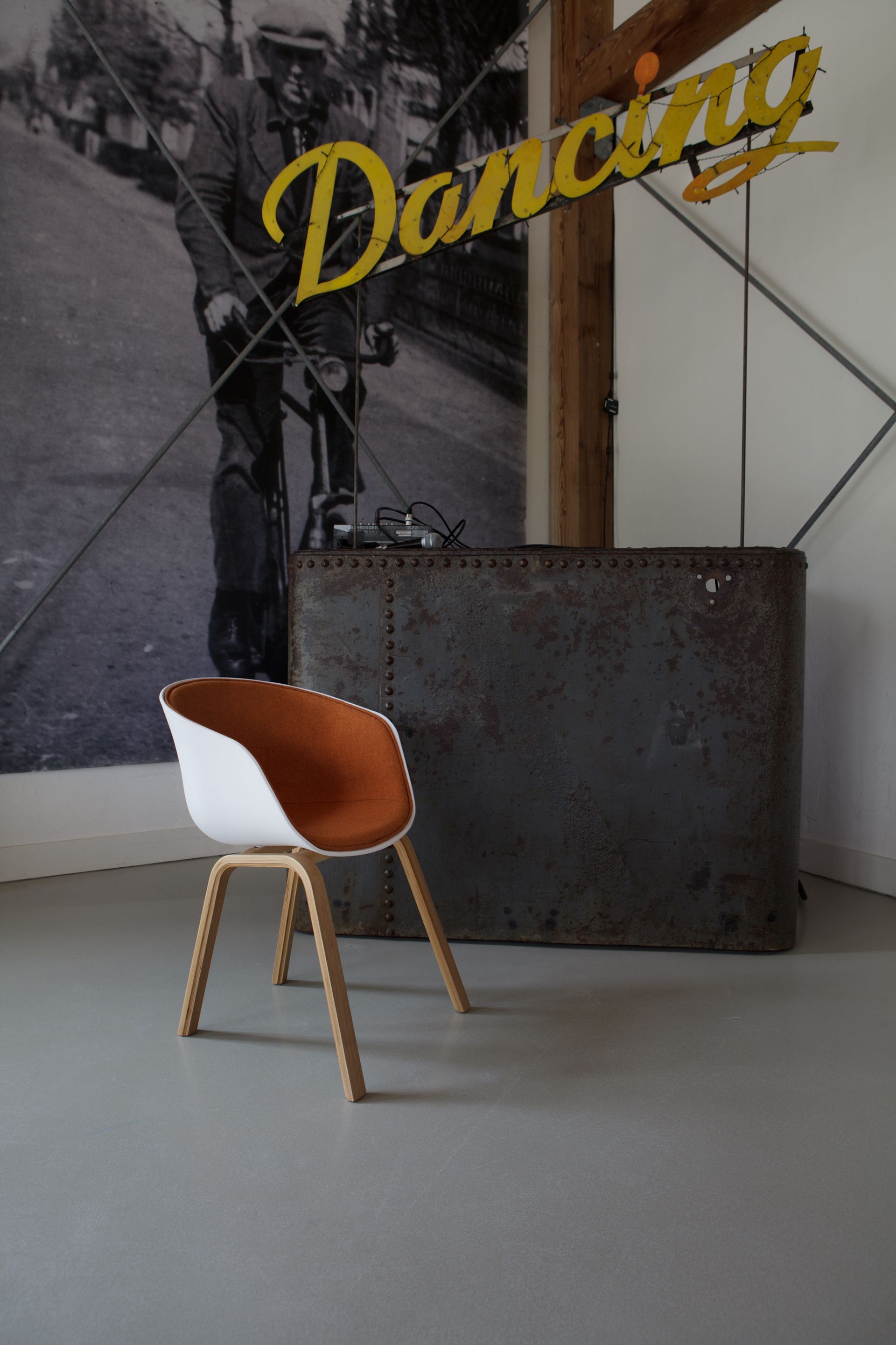 Moderne wit-oranje stoel met houten poten voor een metalen bar .Foto Elise Klinkert