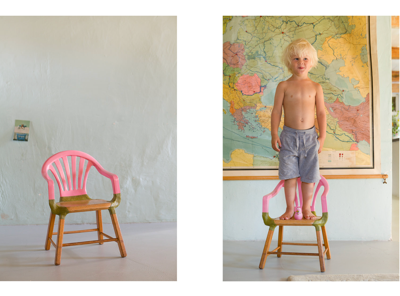 Blond kind staat op een roze en groene stoel voor een wereldkaart, een andere stoel is leeg.