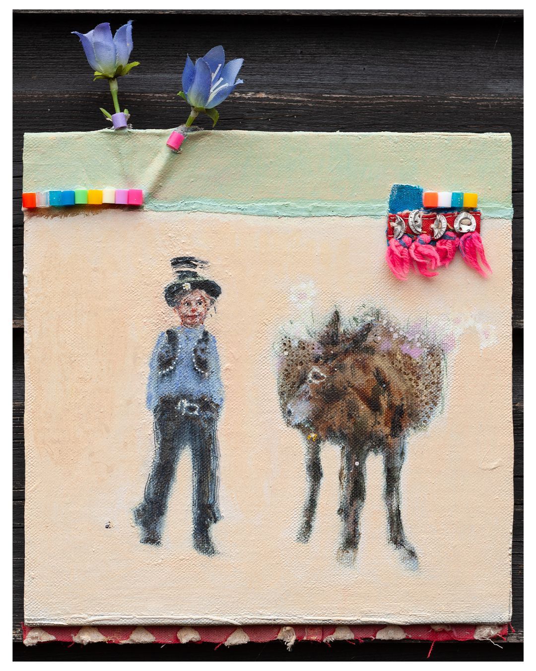 Kind met hoed en ezel. Licht perzikkleurige achtergrond. Versierd met bloemen, strijkkralen en stof