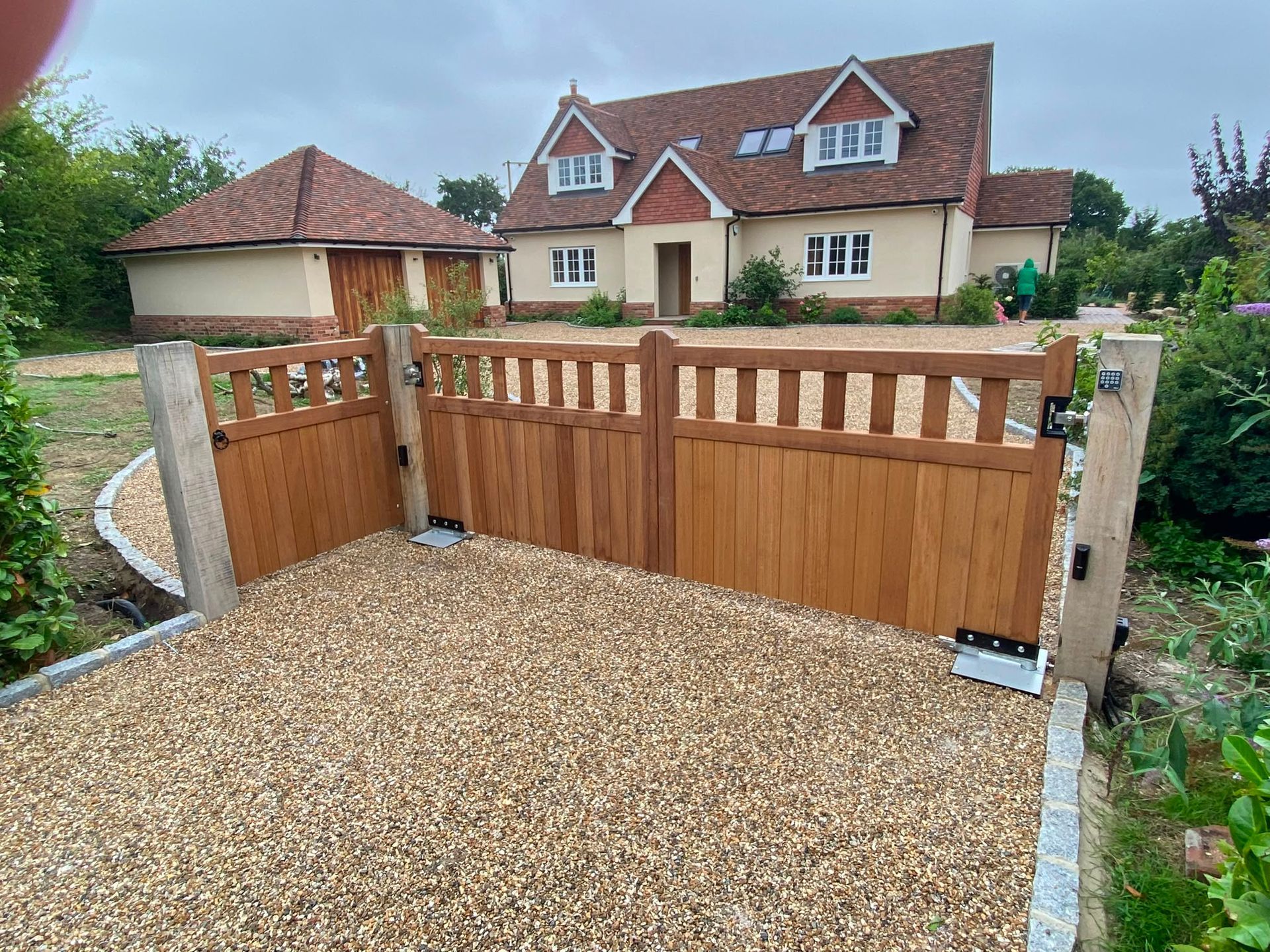 Bespoke iroko swing driveway gates installed at a property in Ashford