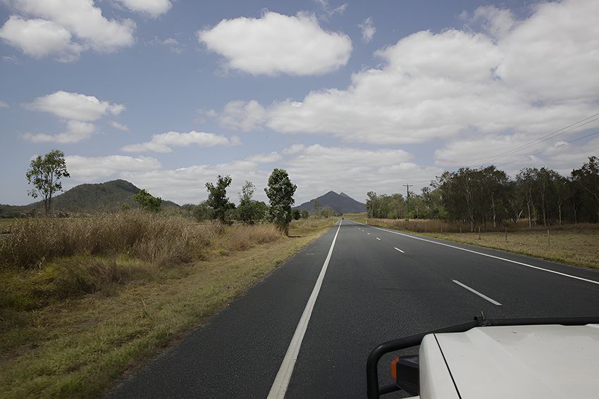 A Car is Driving Down a Road With Mountains — Hardarc Engineering in Dalby, QLD
