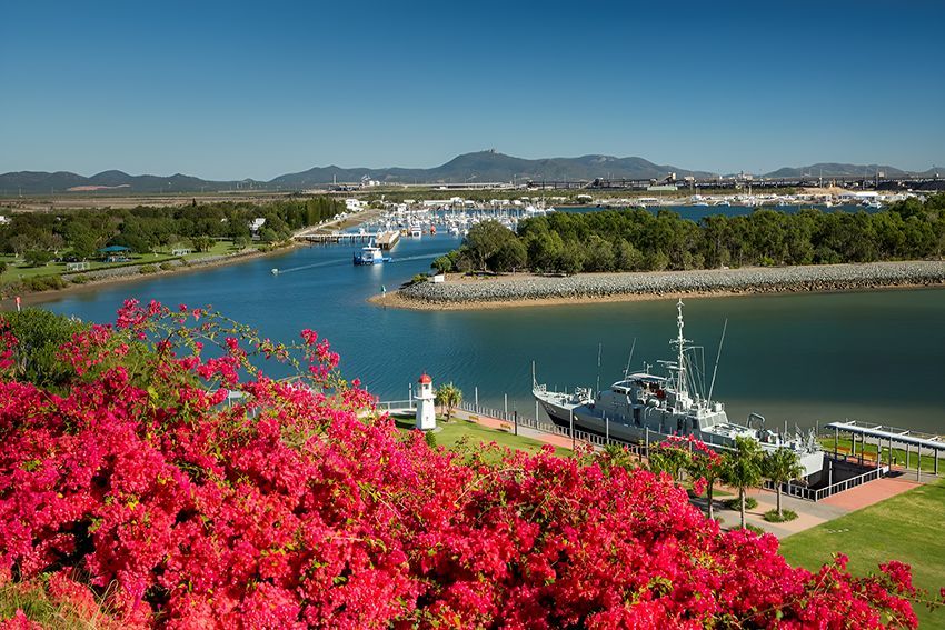 A Boat is Docked in a Harbor With Red Flowers — Hardarc Engineering in Gladstone, QLD