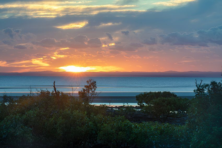 A Sunset Over a Body of Water With Trees — Hardarc Engineering in Hervey Bay, QLD