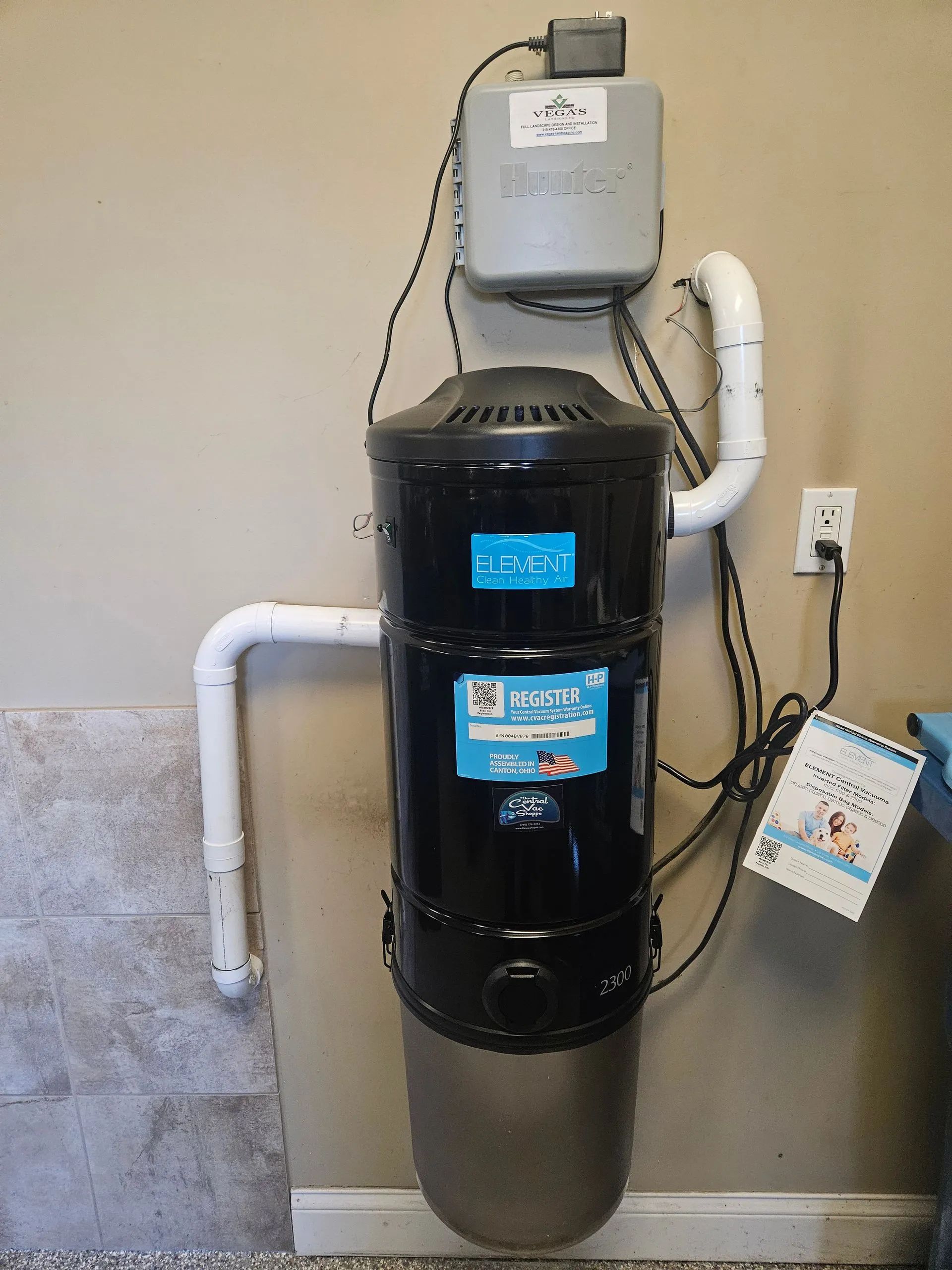 Wall-mounted water heater with digital display and pipes in a utility room